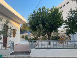 a building with a bench and a tree next to a building at Katofli Holiday Home in Triovasálos