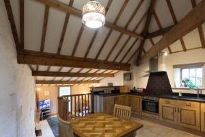 a kitchen with wooden cabinets and a table in a room at Sebright Cottage, Borrowby Farm Cottages in Staithes