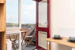 a room with a balcony with a table and a window at Silver Street Suites in Whitby +45 photos