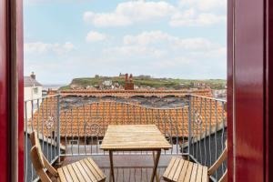 a table and chairs on a balcony with a view at Silver Street Suites in Whitby
