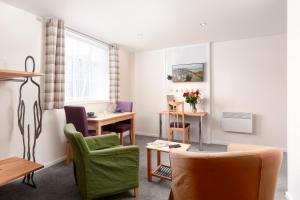 Silver Street Suites في ويتبي: غرفة معيشة مع طاولة وكراسي ومكتب +40 صورة