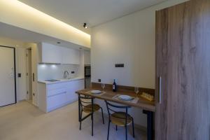 a kitchen with a wooden table and two chairs at Anna's Corfu Cozy Apartment in Corfu