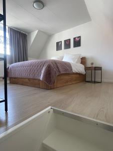 a bedroom with a large bed and a staircase at Wendy's Tiny Beachhouse in Noordwijk +11 photos