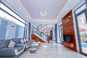 a living room with a couch and a tv at Blue Sea Villa Vung Tau 3 in Vung Tau