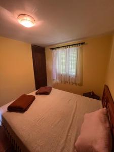 a bedroom with a bed with two towels on it at Vikendica Mali Pozarevac  +14 photos
