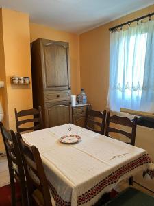 a dining room with a table with chairs and a cabinet at Vikendica Mali Pozarevac 
