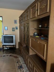 a living room with a television and a large wooden cabinet at Vikendica Mali Pozarevac 