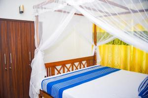 a bedroom with a bed with a canopy at Fieldscape 9 Full APT in Ahangama