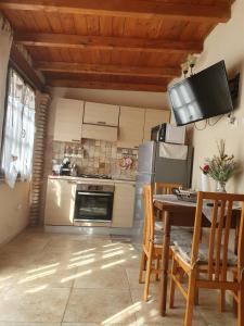 a kitchen with a table with chairs and a refrigerator at Casa Elisa in Flumini di Quartu