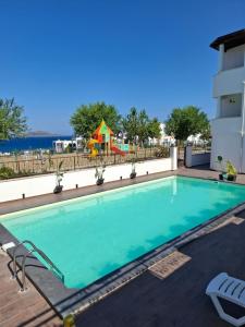 una piscina con un parque infantil en el fondo en Turgutreis Apart Otel, en Bodrum City