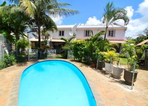 a swimming pool in front of a house at Résidence du Récif - Le Dodo in Bain Boeuf
