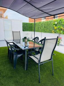 a table and chairs under an umbrella on the grass at Ático Fuengirola Playa Centro Ciudad in Fuengirola