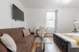 a living room with a couch and a tv at Nestio - Paddington Serviced Studios! in London