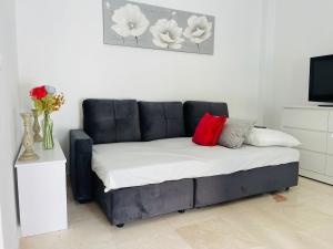 a black couch with two red pillows in a room at Ático Fuengirola Playa Centro Ciudad in Fuengirola