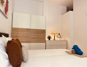 a bedroom with a white bed with a large closet at Ático Fuengirola Playa Centro Ciudad in Fuengirola