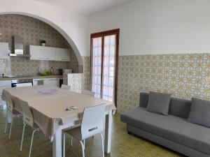 a kitchen and living room with a table and a couch at DonnaPeppina Siracusa in Plemmirio