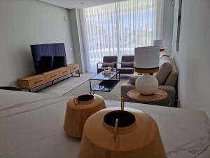 a living room with a couch and a tv at ELEVENLIGHTS-COSTABALLENA Garden View in Costa Ballena