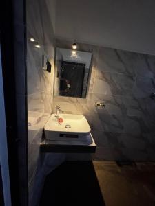 a bathroom with a white sink and a mirror at Skyline Retreat, Tangalle, Sri Lanka in Tangalle