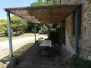a patio with a table and chairs under a brick building at Scappo in Umbria, Collefiorito in Rocchette