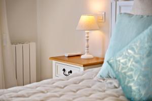 Bett mit Tisch und Lampe in der Unterkunft Villa La Genestière - Familienoase und Golfertraum mit Infinity-Pool und 180-Grad-Panoramablick bis zum Meer in Seillans