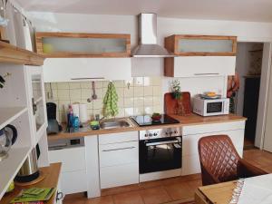 a small kitchen with a sink and a microwave at Ferienwohnung Dießen Bierdorf - Holzacker in Dießen am Ammersee