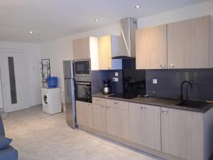 a kitchen with wooden cabinets and a refrigerator at Résidence Maurice in Ax-les-Thermes