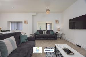 Una sala de estar con un sofá y un televisor de pantalla plana. en 2 Bedroom Apartment By Green Haven Escapes Short Lets & Serviced Accommodation In Leeds with Free WiFi & Parking, en Farnley