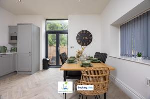 un comedor con una mesa y un reloj en la pared en 2 Bedroom Apartment By Green Haven Escapes Short Lets & Serviced Accommodation In Leeds with Free WiFi & Parking, en Farnley