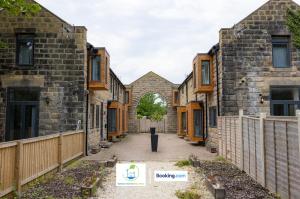 una fila de casas de ladrillo con una valla en 2 Bedroom Apartment By Green Haven Escapes Short Lets & Serviced Accommodation In Leeds with Free WiFi & Parking, en Farnley