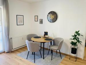 a dining room table with chairs and a clock on the wall at Apartment beim Schloss Ort mit Balkon und Parkplatz in Gmunden