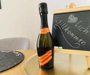 a bottle of wine on a table next to a chalkboard at Apartment beim Schloss Ort mit Balkon und Parkplatz in Gmunden +5 photos
