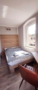 a bedroom with a bed with a window and a chair at Ferienwohnung Lessing in Meißen