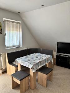 a room with a table and two chairs and a television at Bodza Vendégház in Balatonfüred