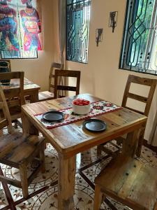 a wooden table with two chairs and a bowl of food on it at ZanziBalkan House Nungwi in Nungwi +38 photos