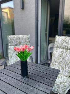 a vase of pink flowers sitting on a wooden table at SALVIA II exklusiv & smart & Terrasse II Dein City-Apartment in Braunschweig