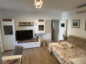 a bedroom with a bed and a flat screen tv at Apartment Rita in Makarska