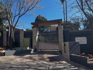 a gate in front of a fence with a sign at Marion Lodge in Johannesburg