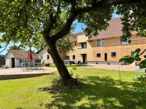 a tree in the grass in front of a building at Lot54 Holiday Homes in Feuerscheid