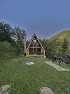a log cabin in the middle of a grass field at A Way To Nature in Măgura