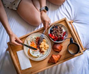 een dienblad met ontbijtproducten op een bed bij Hôtel Vendome Saint-Germain in Parijs +74 foto's