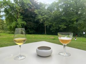 two glasses of white wine and a bowl on a table at Glamping du Manoir de la Douve in Heuvelland