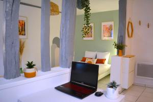 un computer portatile su una scrivania in una camera con un letto di Le Panama - 5 min du centre, 500m2 de jardin a Évreux