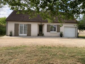 a white house with a garage at Gîte Au Cœur des Châteaux in Cheverny +4 photos