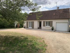 a white house with a garage and a driveway at Gîte Au Cœur des Châteaux in Cheverny