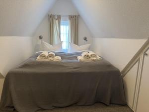 a bedroom with a bed with towels on it at Strand-Lug Wenningstedt in Wenningstedt