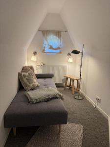a room with a couch in the corner of a attic at Strand-Lug Wenningstedt in Wenningstedt
