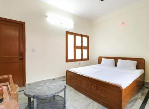 a bedroom with a bed and a table and a window at HOTEL SHREE BHAMESHWAR Near Mansa Devi Temple and Chandi Devi Temple# Ganga River - Fully Air conditioned Rooms - Best Budget Hotel in Haridwār