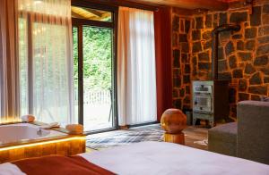 a bedroom with a bed and a tub and a window at River Villas Resort in Çamlıhemşin +67 photos