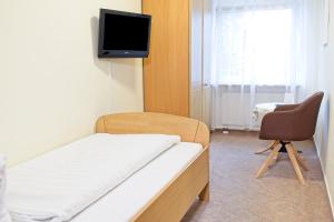 a hospital room with a bed and a chair at Hotel Adler in Mainz