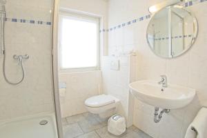 a bathroom with a sink and a toilet and a mirror at Hotel Adler in Mainz +4 photos
